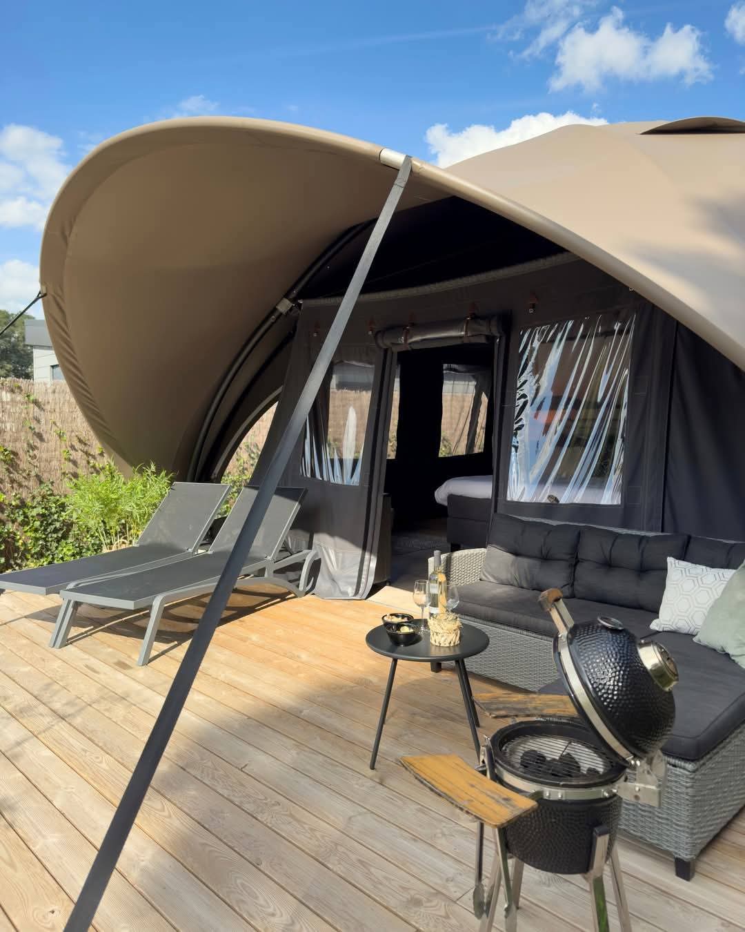 A luxury safari tent with a comfortable outdoor lounge area