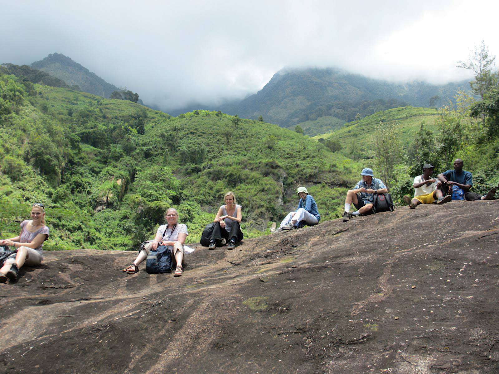 Hikers interacting with local tribesmen in a natural setting in Luguru