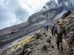 Trekkers ascending a rocky peak, representing the climb of Ol Donyo Lengai
