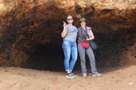 View of a savanna with zebras framed by the opening of a large cave