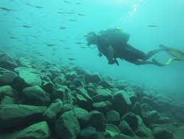 A tourist swimming in the clear waters of Kuza Cave